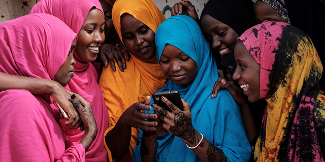 Young Somali women look at a smartphone at Dadaab refugee complex, in northeast Kenya, on April 16. (Yasuyoshi Chiba/AFP/Getty Images)
