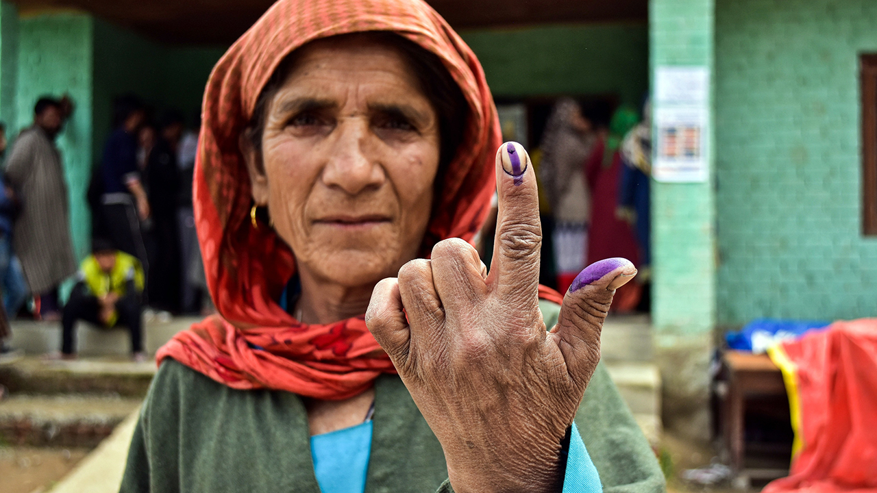 A woman shows her inked finger after voting in a village near Srinagar, India. (Saqib Majeed/SOPA Images/LightRocket via Getty Images)