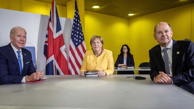 Image shows U.S. President Joe Biden meeting with outgoing German Chancellor Angela Merkel and current Vice Chancellor Olaf Scholz on the sidelines of the G20 summit in Rome on Oct. 30, 2021.