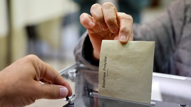 A voter drops his ballot into a box at a polling station in northern France on June 19, 2022. (Ludovic Marin/AFP via Getty Images)