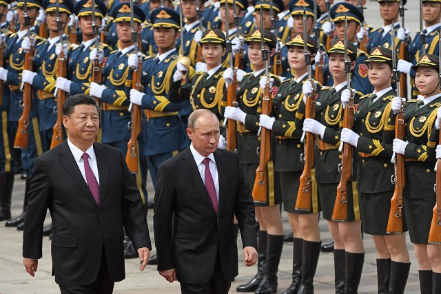Photo showing Russian President Vladimir Putin walks with Chinese President Xi Jinping in front of a military honor guard during a welcoming ceremony in Beijing in June 2018. (Photo by Greg Baker/Pool/AFP via Getty Images)