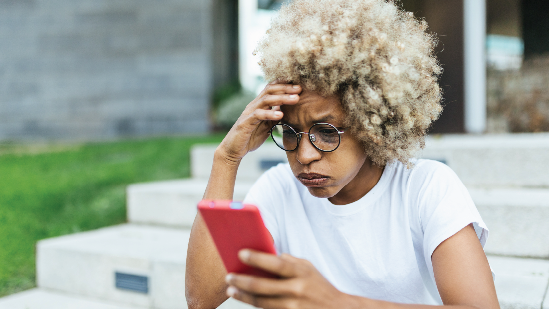 An image of a woman with a concerned expression on her phone.