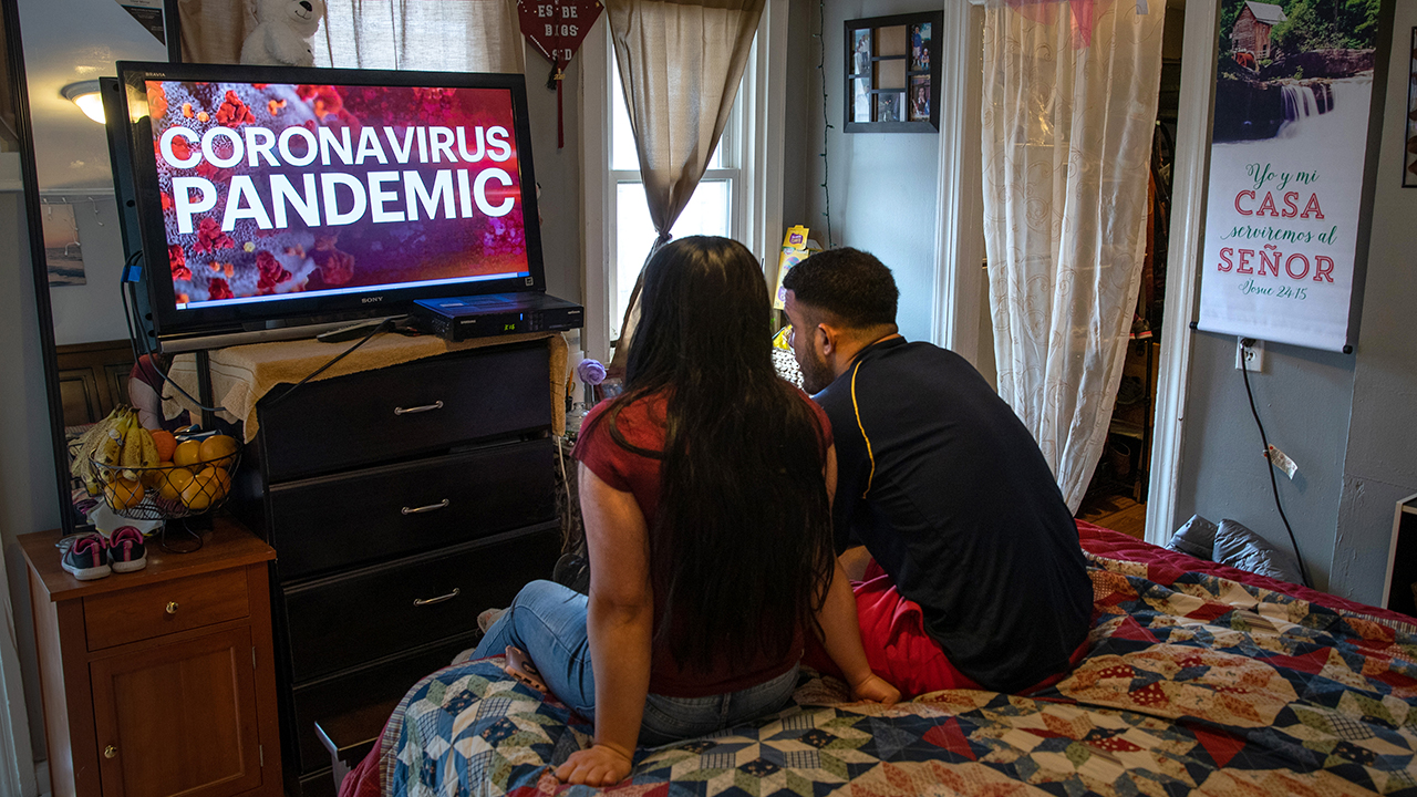 A couple in Norwalk, Connecticut, watch TV news on March 25. Both lost their jobs due to the COVID-19 outbreak. (John Moore/Getty Images)