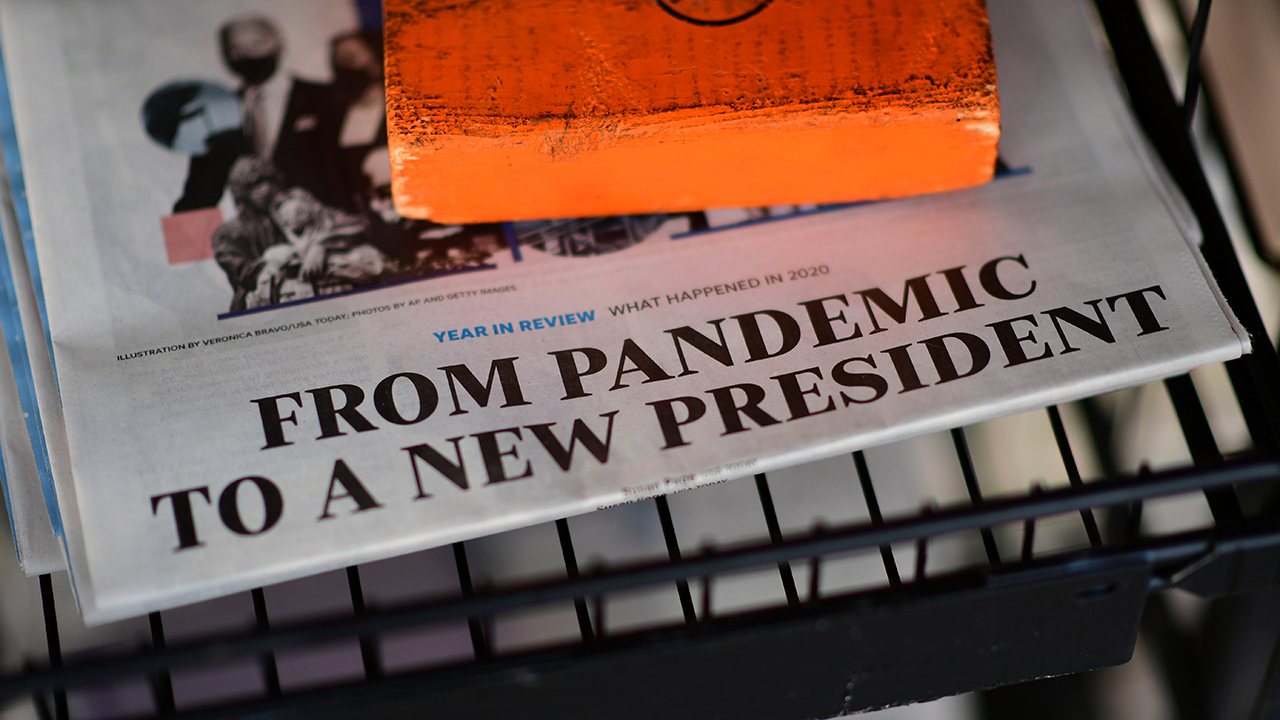 The front page headline of a newspaper states "FROM PANDEMIC TO A NEW PRESIDENT" on December 31, 2020 in Rehoboth Beach, Delaware. (Mark Makela/Getty Images)
