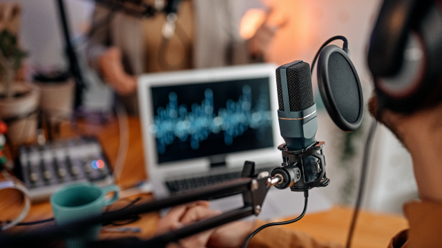 An image showing Selective focus of microphone used by young man and woman while recording podcast during interview and doing live broadcast in studio