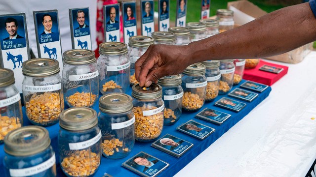 A photo of people put kernels into jars representing presidential candidates in a "corn poll" at the the Iowa State Fair on Aug. 11. (Alex Edelman/AFP/Getty Images)