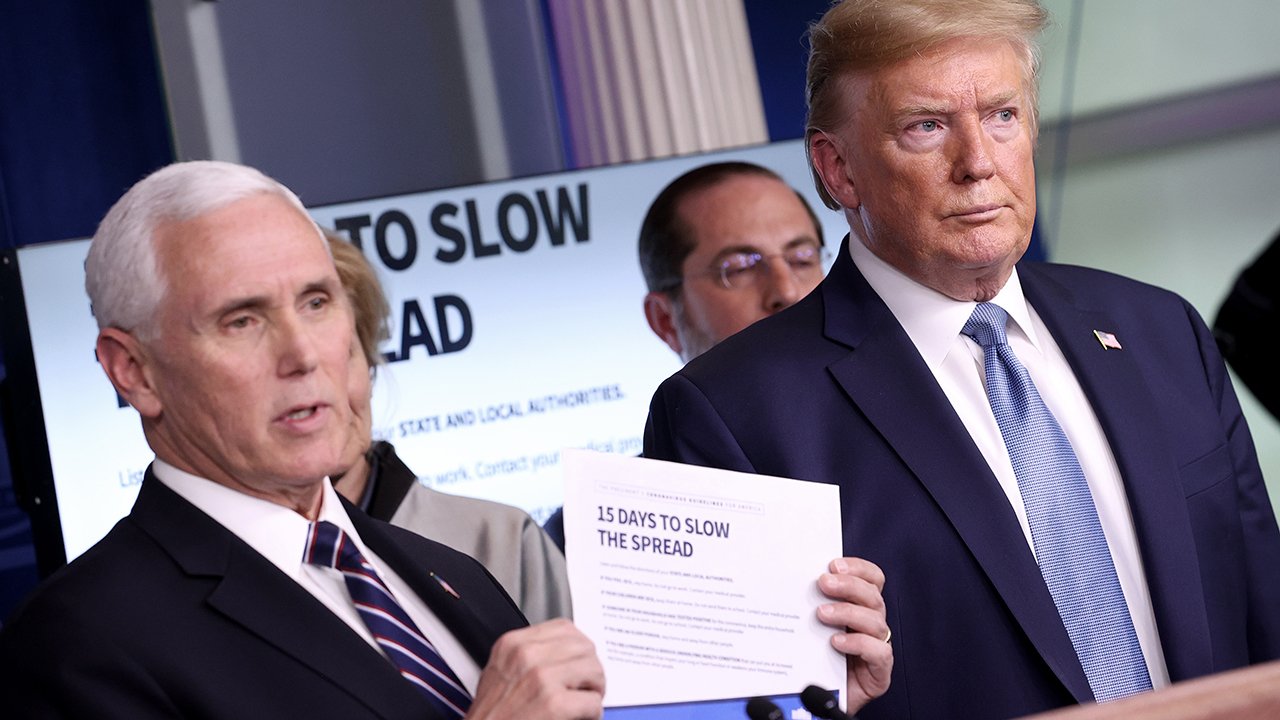 Vice President Mike Pence and President Donald Trump speak to journalists about the coronavirus in the White House press briefing room on March 16. (Win McNamee/Getty Images)