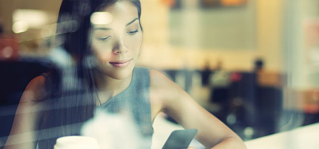 Woman using smart phone in coffee shop