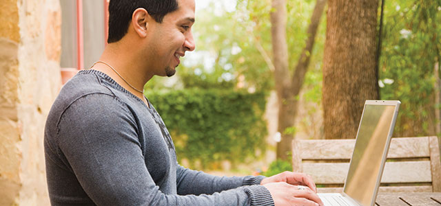 Young man using a laptop outside