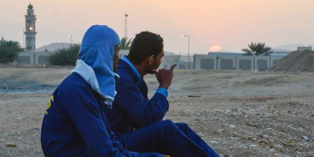 Construction workers from India wait for transportation near the Grand Hormuz Hotel in Muscat, Oman. (Artur Widak/NurPhoto via Getty Images)