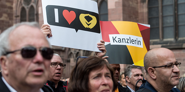 Supporters of German Chancellor Angela Merkel, top candidate for the conservative Christian Democratic Union party in the upcoming general elections, hold up posters to cheer for her during an election campaign event in Freiburg, southwestern Germany, on Sept. 18, 2017. (Patrick Seeger/AFP/Getty Images)