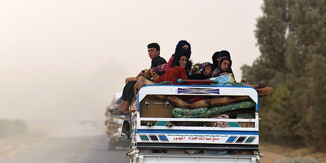 Displaced Syrians from Deir Ezzor head to refugee camps on the outskirts of Raqqa on Sept. 24 as Syrian fighters backed by U.S. special operations forces battle to capture ISIS's last remaining stronghold. (Bulent Kilic/AFP/Getty Images)