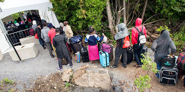 Asylum seekers wait to cross the border into Canada near Champlain, New York, in August 2017. (Geoff Robins/AFP/Getty Images)