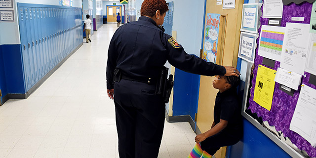 Tiffany Wiggins, a school police officer in Baltimore, talks with a student at Thomas Jefferson Elementary/Middle School in 2015. (Matt McClain/The Washington Post via Getty Images)