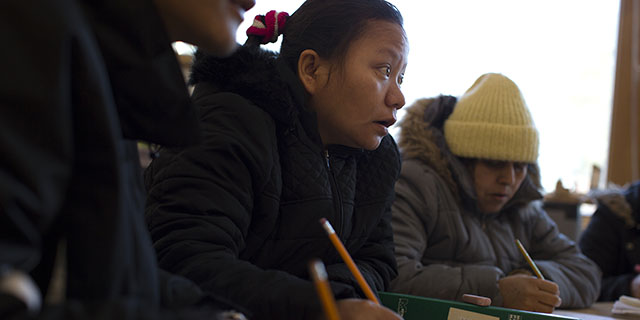 Tika Gurung takes notes during an English class in Burlington, Vermont. Her extended family was resettled in the area, as were hundreds of other refugees from Bhutan and Nepal in recent years. (Robert Nickelsberg/Getty Images)