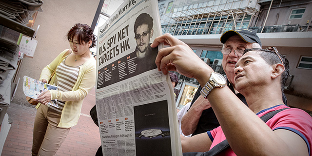 When National Security Agency contractor Edward Snowden released classified documents detailing U.S. government interception of phone calls and electronic communications, it made headlines around the world. Here, two men in Hong Kong read a newspaper in June 2013. (Philippe Lopez/AFP/Getty Images)