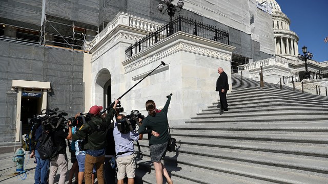 Photo of journalists shouting questions at Rep. Ron Estes as he heads into the U.S. Capitol in September.
