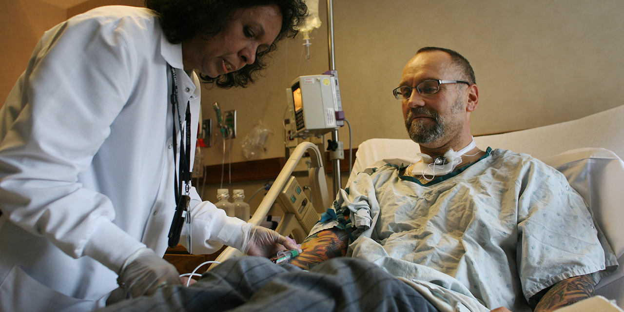 A Burmese immigrant phlebotomist at St. Joseph's Hospital in St. Paul, Minnesota, draws blood from a patient. (Jerry Holt/Star Tribune via Getty Images)