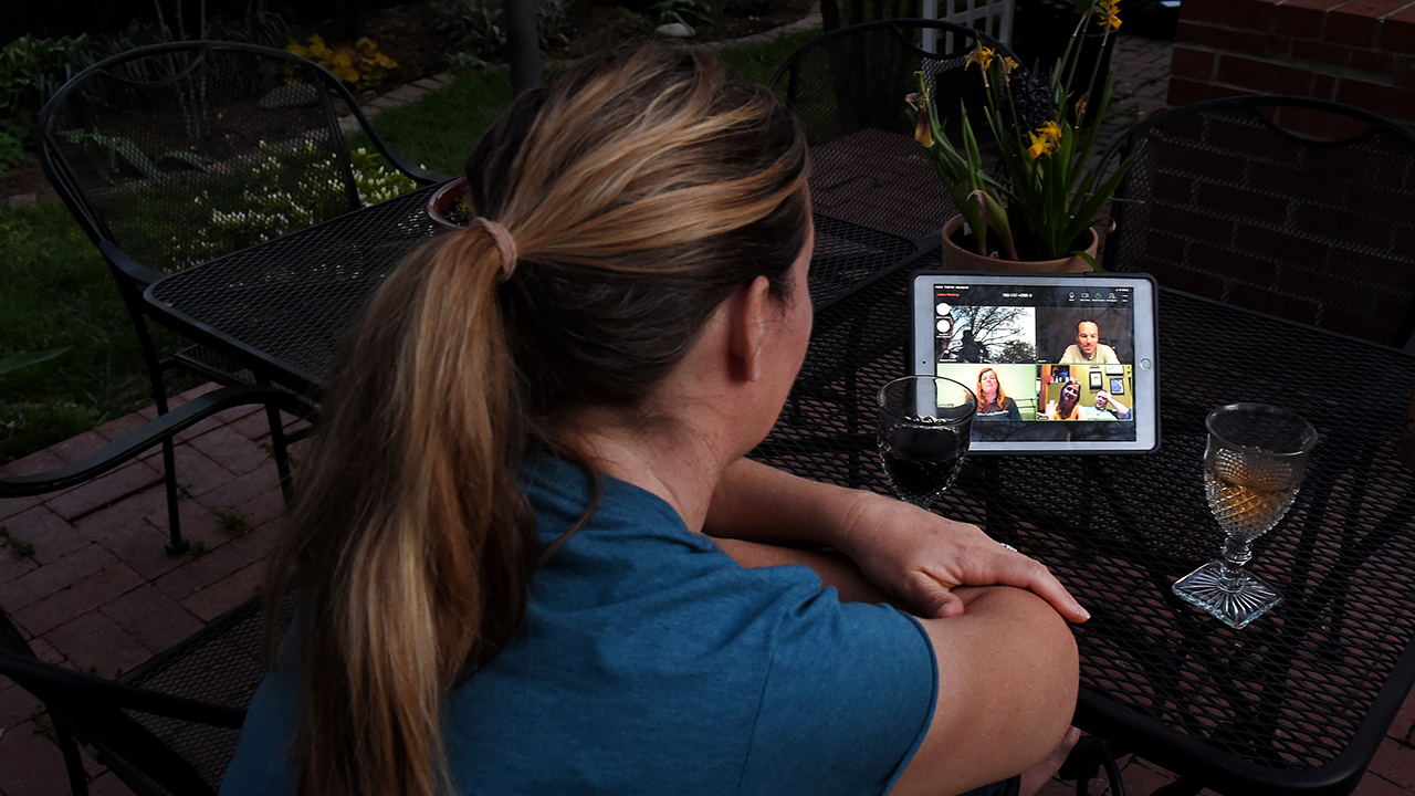 A woman in Arlington, Virginia, enjoys a virtual happy hour on April 8 as local bars remain closed. (Olivier Douliery/AFP via Getty Images)