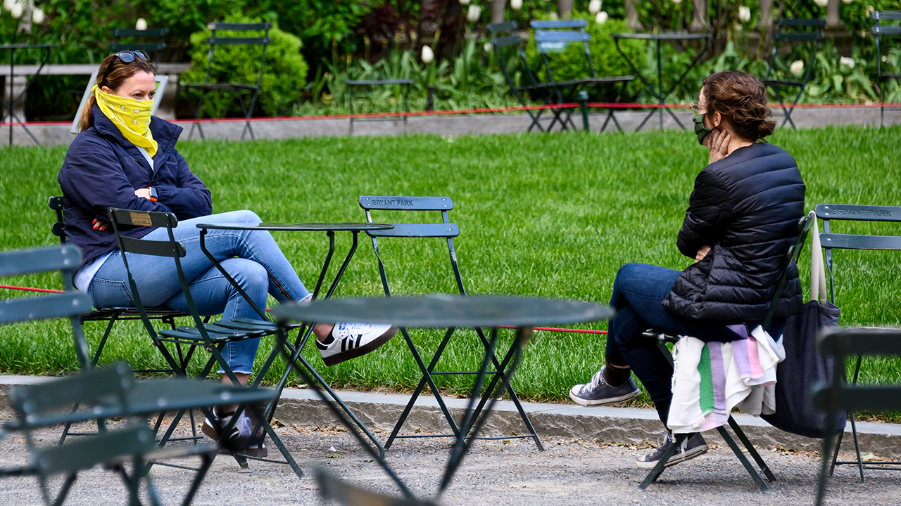 Women talk in New York City's Bryant Park while wearing protective masks on May 7. (Noam Galai/Getty Images)