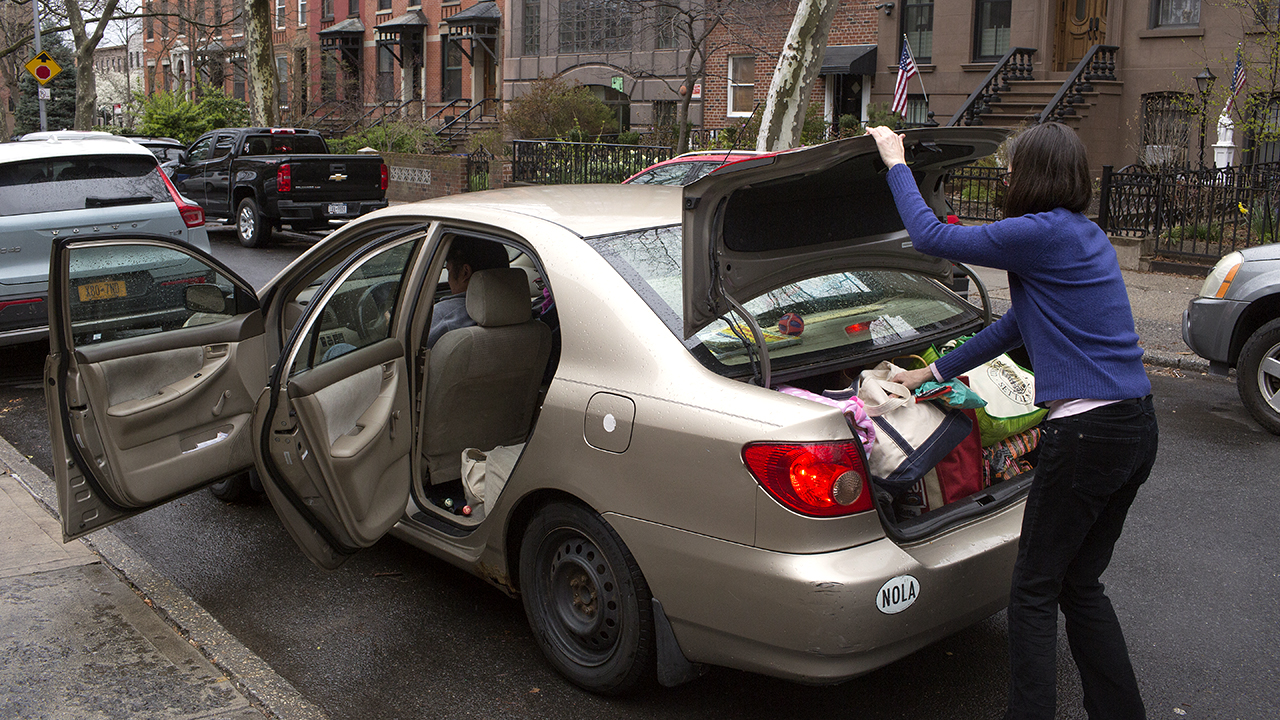 A Brooklyn family prepares to leave New York City on March 25 due to concerns about the spread of COVID-19. (Andrew Lichtenstein/Corbis via Getty Images)