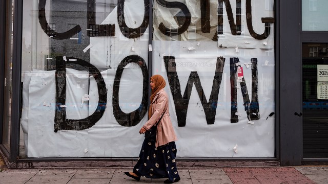 A woman walks past a closed shop in London on June 28. (Hollie Adams/Getty Images)