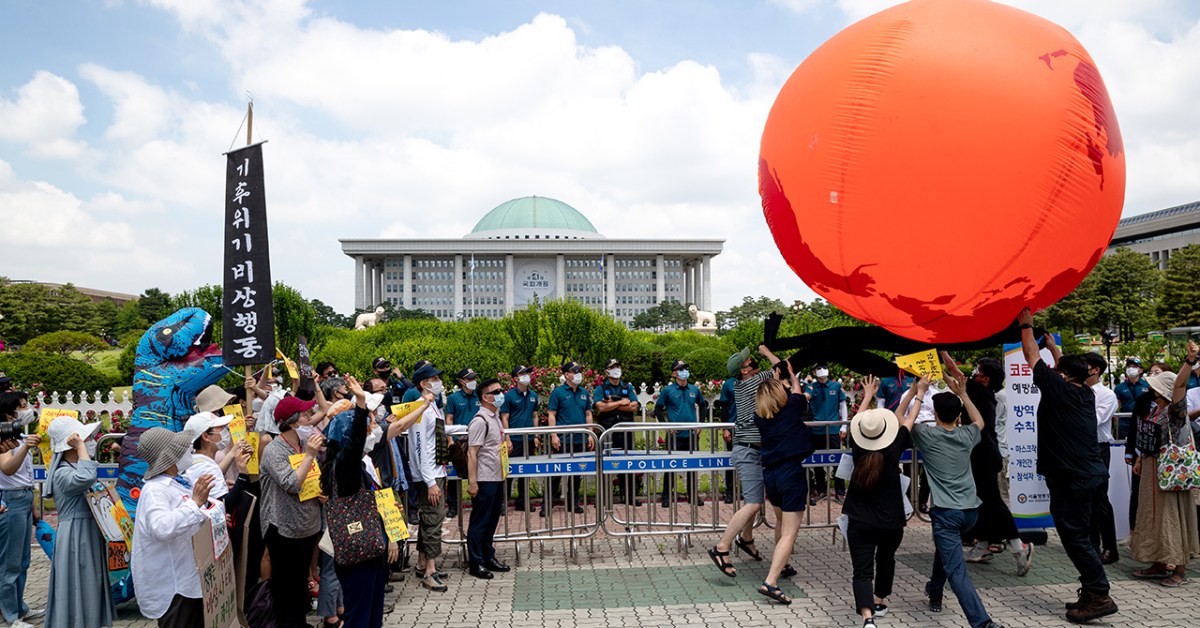 Climate activists hold a large red balloon representing the Earth on June 11, 2020, in Seoul, South Korea. (Chris Jung/NurPhoto via Getty Images)
