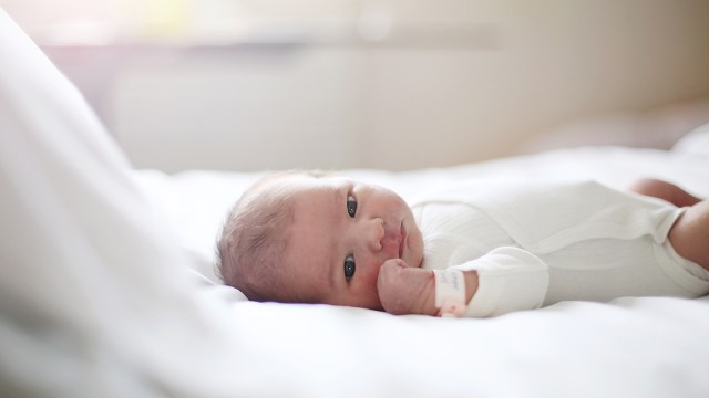 A newborn baby lying in a crib.