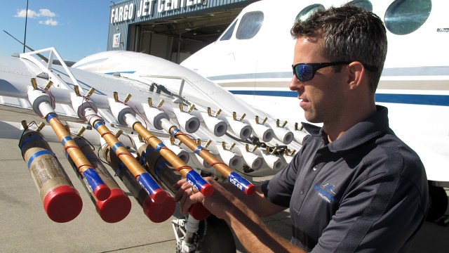 Jody Fischer adjusts flares used to seed clouds on a plane for Weather Modification Inc. in Fargo, North Dakota, in 2017. (Dave Kolpack/AP)