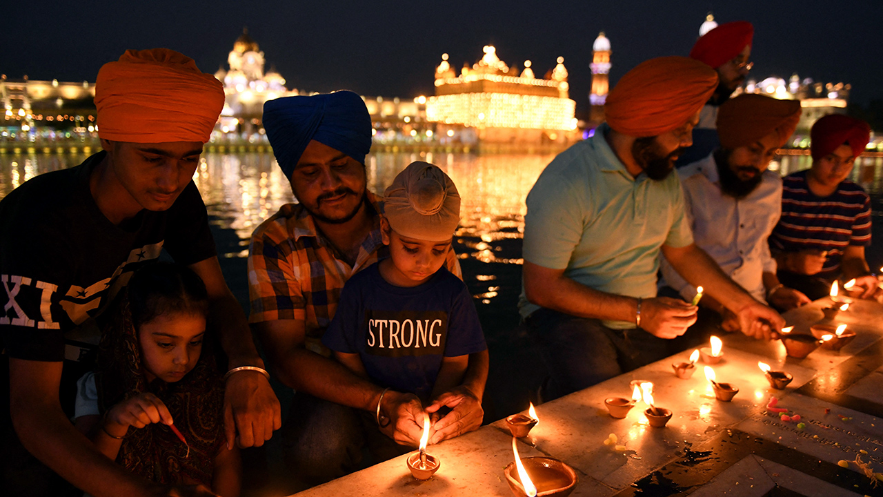 I devoti Sikh accendono candele al Tempio d'oro di Amritsar, in India, il 25 giugno 2021. (Narinder Nanu/AFP via Getty Images)