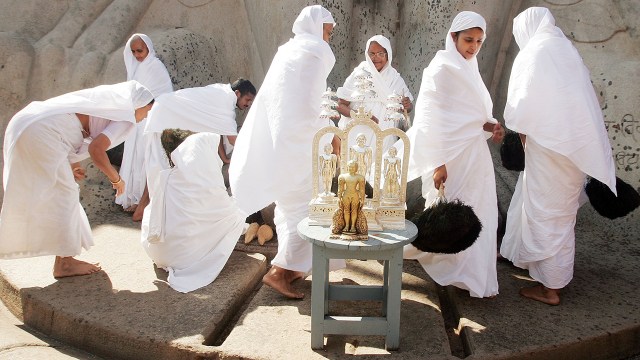 Jain nuns gather beneath the monolithic statue of Gommateshvara during the first day of the Mahamastakabhisheka ceremony on Feb. 8, 2006, in Shravanabelagola, India.