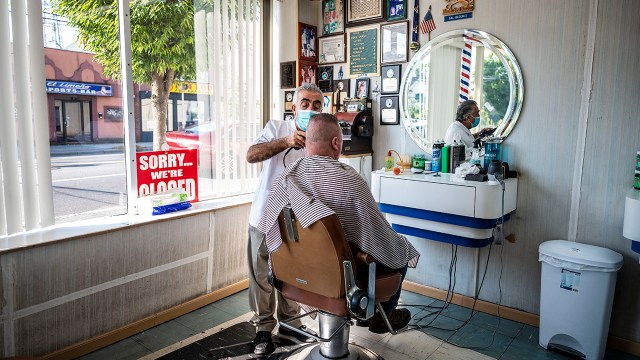 Sal Bademci works on a customer at his Patchogue, New York, barbershop in August 2021.
