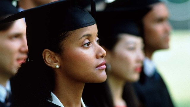 College graduates sit at a commencement ceremony.