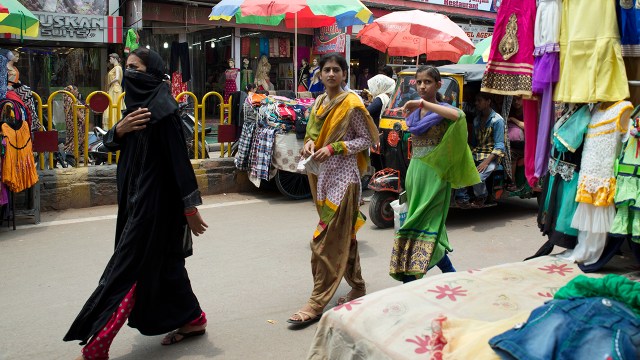 Women walk by town shops in Uttar Pradesh, India, in 2016.