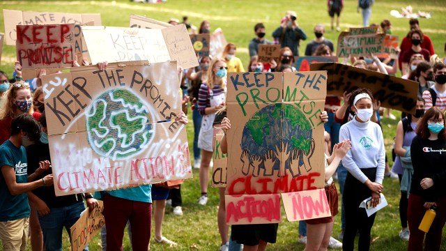 Protesters hold signs to advocate for carbon neutrality during the Keep the Promise rally in Bloomington, Indiana, in March 2021.