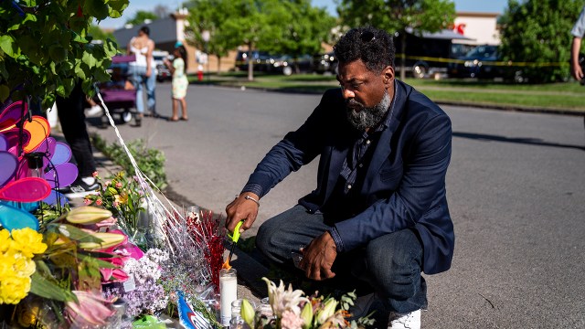 A man pays his respects at the scene of a mass shooting at Tops Friendly Market on May 15, 2022, in Buffalo, New York.