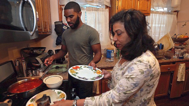 A recent college graduate prepares a meal with his mother at her home in Boston in May 2018.