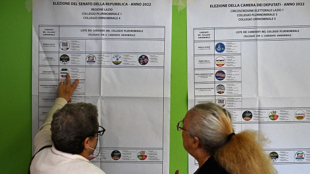 People look over a list of legislative candidates at a polling station in Rome on Sept. 25, 2022.