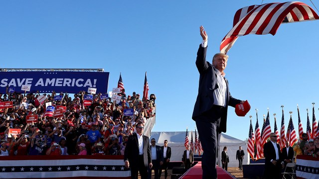 Former President Donald Trump tosses Save America hats to the crowd at a campaign rally on Oct. 9, 2022, in Mesa, Arizona.