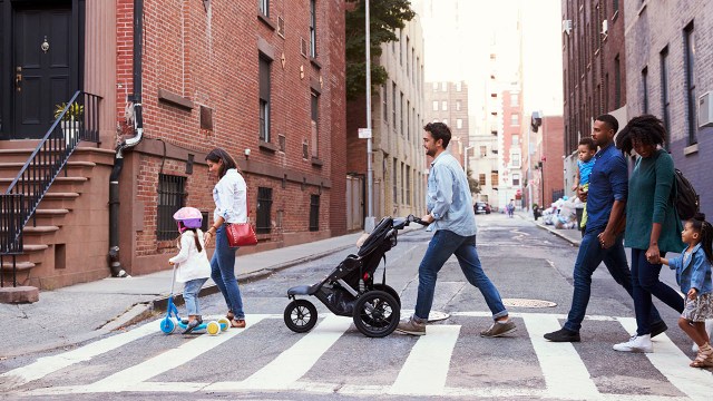 Parents walk across a crosswalk with their kids