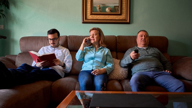 Family members doing different things in their living room.