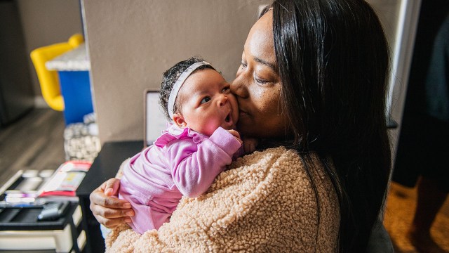 A mother kisses her newborn baby. (Brandon Bell/Getty Images)