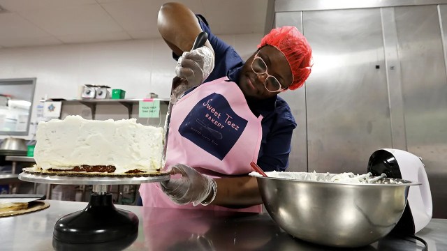 Teresa Maynard, owner of Sweet Teez Bakery in Boston, frosts a vanilla cake at a commercial kitchen. (Pat Greenhouse/The Boston Globe via Getty Images)