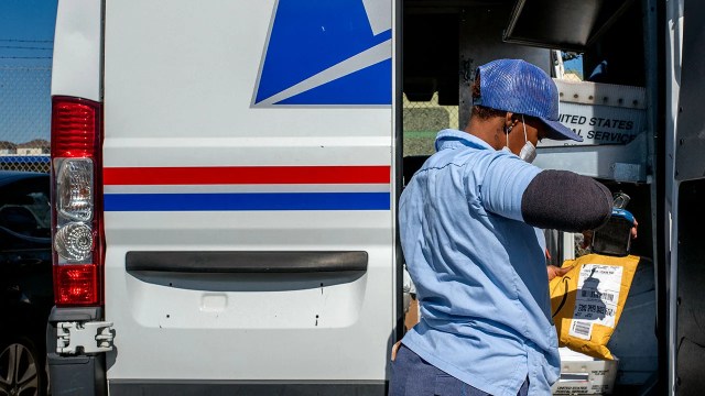 A U.S. Postal Service employee scans a package. (Brandon Bell/Getty Images)