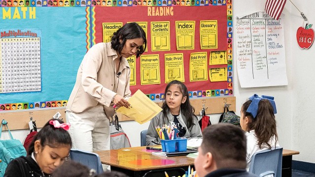 A teacher works with students at Nevitt Elementary School in Phoenix, Arizona. Arizona, like a majority of states, mandates a 180-day school year for K-12 public schools. (Olivier Touron/AFP via Getty Images)