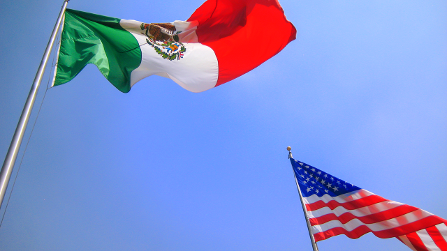 A Mexican and American flag on flagpoles.