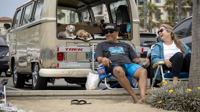 Mike and Amber Perez and dogs Ziggy and Taz relax beachside for Independence Day weekend in Huntington Beach, California, on July 1, 2023. (Allen J. Schaben/Los Angeles Times via Getty Images)