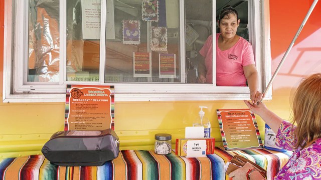A customer pays for her meal at a Mexican food truck in Indiantown, Florida. (Jeff Greenberg/Education Images/Universal Images Group via Getty Images)