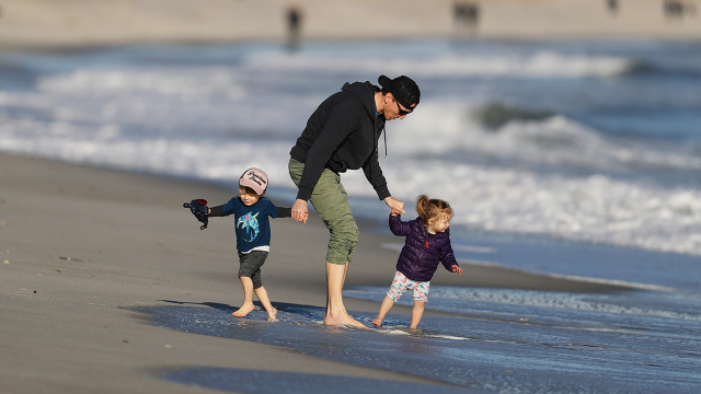 A father plays with his children in Lido Beach, New York. (Al Bello/Getty Images)