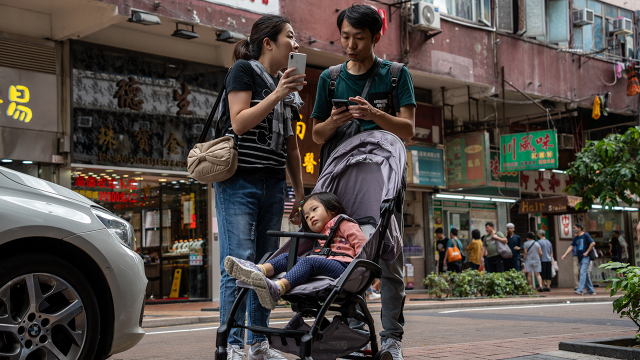A couple with a baby stroller explores town in Hong Kong. (Vernon Yuen/NurPhoto via Getty Images)
